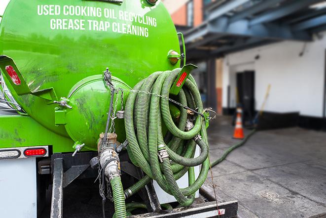 a grease trap being pumped by a sanitation technician in Grand Rapids